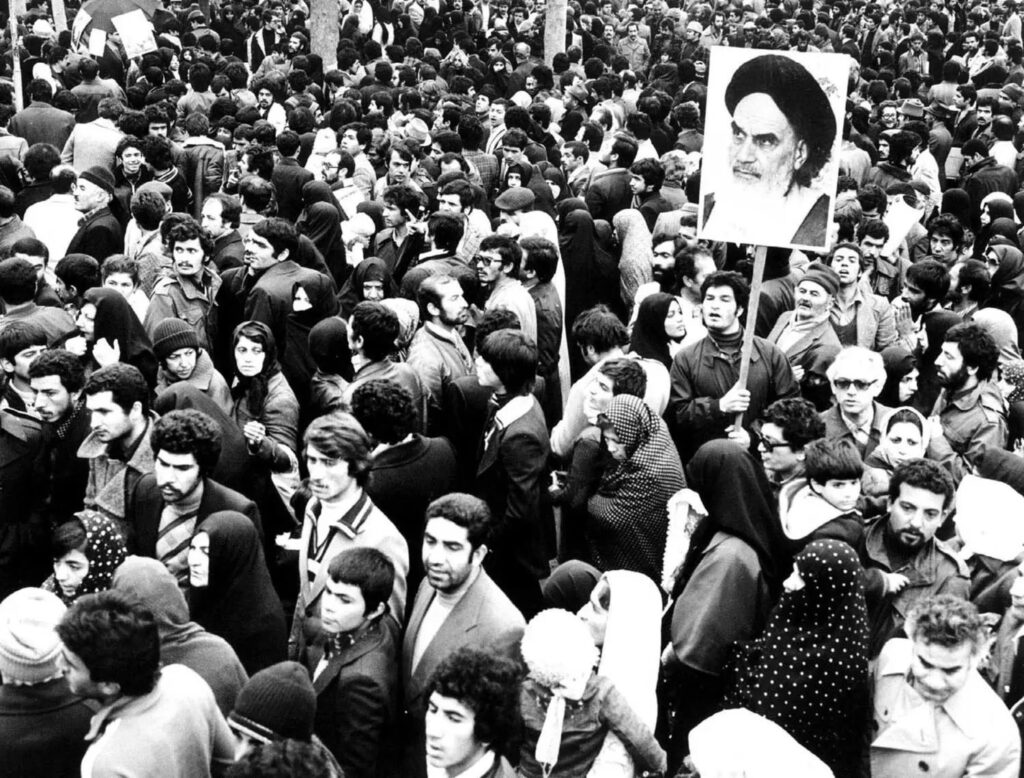 Supporters gather during the 1979 Iranian Revolution holding a portrait of Ayatollah Ruhollah Khomeini in Tehran
